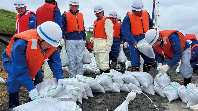 総合水防訓練で土のうを積み上げる参加者