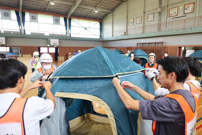 テントの組み立て方法を確認する参加者