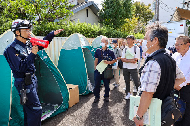 防災担当者からトイレの説明を聞く参加者