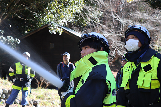 真剣な表情で消火訓練を行う団員