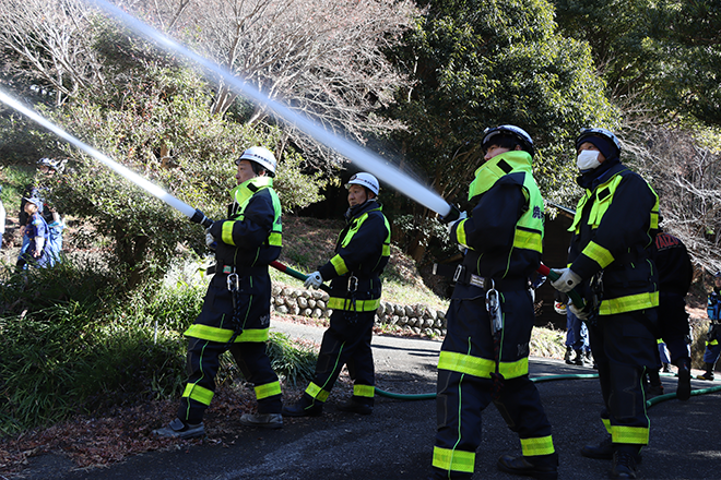 真剣な表情で消火訓練を行う団員たち