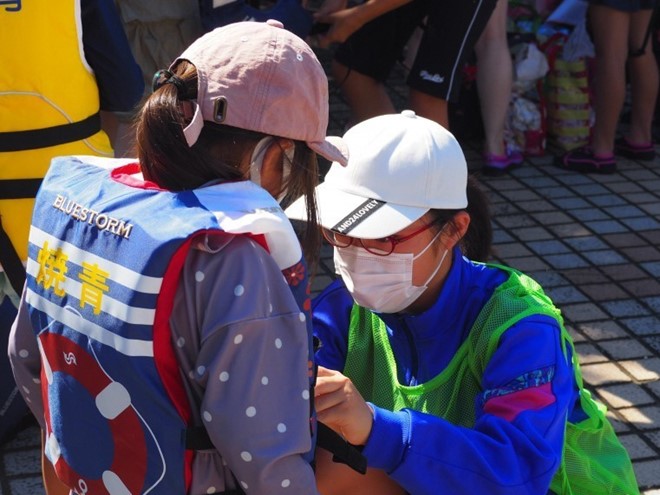 ライフジャケットの装着を手伝う東益津中学校生