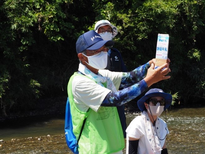 牛乳パックで作った水中箱メガネを説明する様子