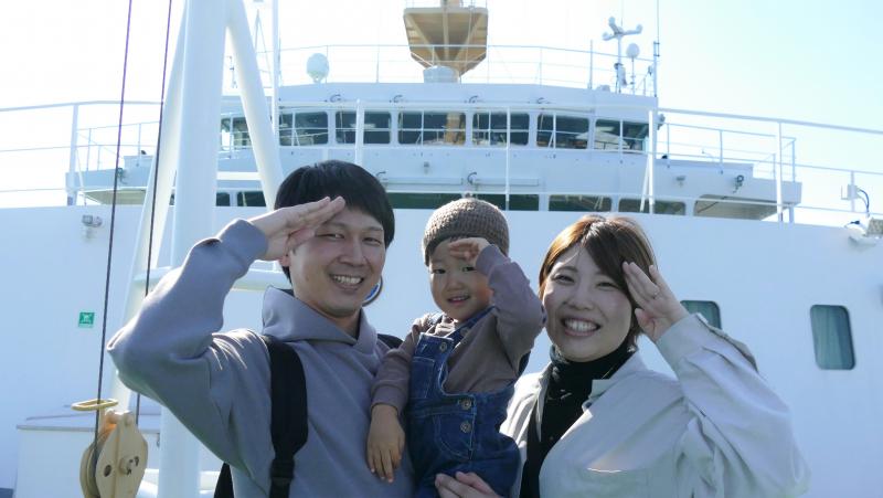 練習船「大成丸」の前でポーズをとる家族